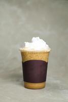 ghiacciato miscelato nocciola latte macchiato caffè servito nel monouso tazza isolato su grigio sfondo superiore Visualizza di bar dolce foto