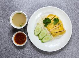 hai nam pollo nel tailandese stile con Riso, melone la minestra e chili salsa servito nel piatto isolato su grigio sfondo superiore Visualizza di hong kong cibo foto