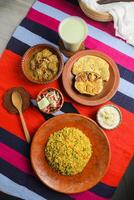 acari pollo khichuri combo con uovo pianta e frittata, Borhani, insalata e chui pitha servito nel piatto isolato su stuoia superiore Visualizza di indiano e bangladeshi cibo foto