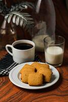 croccante biscotti biscotti servito nel piatto con nero caffè e bicchiere di latte isolato su tavolo lato Visualizza di americano bar al forno cibo foto