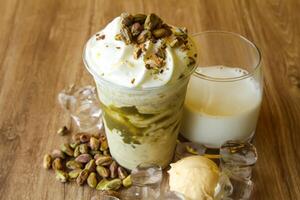 pistacchio frappè con ghiaccio crema notizia in anticipo servito nel monouso bicchiere con ghiaccio cubo isolato su tavolo lato Visualizza di salutare mattina latte shake bevanda foto