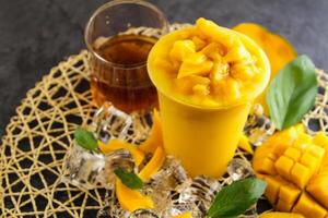 fresco Mango succo servito nel monouso bicchiere isolato su tavolo lato Visualizza di salutare mattina succo bevanda foto