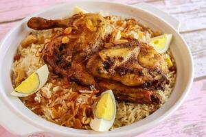 pollo mandi biryani pulao riso con bollito uovo servito nel pentola piatto isolato su di legno tavolo superiore Visualizza Arabo speziato cibo foto