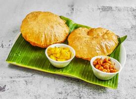 povera impostato o puri con chnnay e veg curry con chutney, raita e salsa servito nel piatto isolato su Banana foglia superiore Visualizza di indiano e Singapore speziato cibo foto