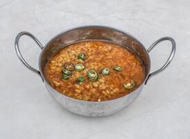 daal miscuglio friggere o dal mash fritte lenticchia con verde peperoncino servito nel karahi isolato su grigio sfondo lato Visualizza di pakistano prima colazione e indiano spezie cibo foto