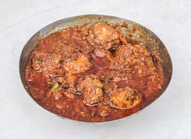 speziato pollo karahi korma masala con sugo servito nel karahi isolato su grigio sfondo lato Visualizza di pakistano e indiano spezie cibo foto