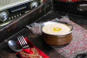 hareesa o lepri arabo piatto servito nel piatto isolato su rosso stuoia superiore Visualizza su tavolo Arabo cibo foto