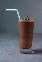 freddo cioccolato servendo nel bicchiere con cannuccia lato Visualizza su sfondo foto