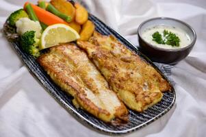 grigliato amore pesce con fritte verdure, Limone e insalata servito nel piatto isolato su cibo tavolo superiore Visualizza di mezzo est spezie foto