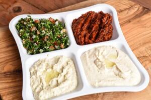 tabbouleh insalata, speziato shatta salsa, mutabale, hummus foto