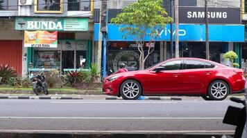 rosso auto mazda parcheggiata su il strada contro il sfondo di il soleggiato cielo. settore automobilistico fotografia. foto