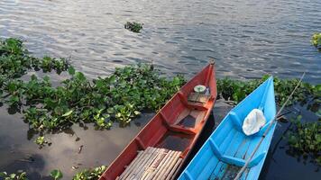 colorato pesca barca nel un' calma lago acqua. vecchio di legno pesca barca nel un' ancora lago acqua foto