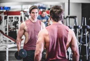 bell'uomo muscoloso con manubri in palestra foto