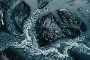 ai generato dall'alto al basso aereo Visualizza di un' glaciale fiume con intricato modelli, mostrando contrastante buio acqua contro bianca neve. foto