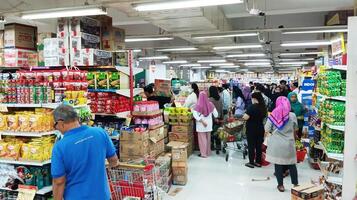 semarang, Indonesia - marzo 10, 2024 - persone a supermercato. consumatori visitare drogheria negozio, acquisti. acquirenti, i clienti con carrelli foto