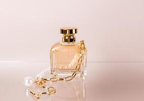 un' elegante bottiglia di Da donna o Uomini profumo su un' bicchiere superficie con un' perla oro collana. davanti Visualizza pastello sfondo. vuoto confezione. presentazione foto