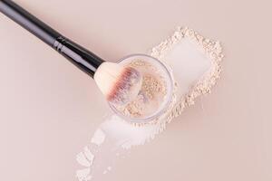 bicchiere vaso con perdere polvere, swatch polvere e trucco spazzola, l'applicazione polvere su viso su beige sfondo. concetto di cosmetici , trucco. superiore Visualizza foto