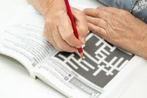 alzheimer malattia anno Domini, asiatico anziano donna giocando sudoku puzzle gioco per pratica per demenza prevenzione. foto