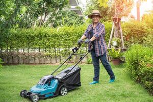 la macchina per il movimento del prato taglia l'erba verde, piantagione di hobby nel giardino di casa. foto