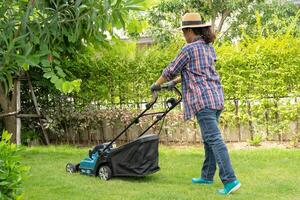 la macchina per il movimento del prato taglia l'erba verde, piantagione di hobby nel giardino di casa. foto