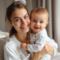 sorridente giovane madre Tenere sua bambino in casa foto