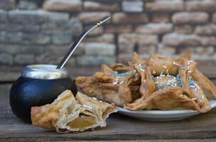 yerba compagno e fritte pasticcini, simboli di il argentino tradizione foto