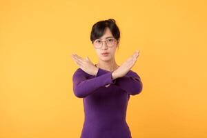 foto di bella fiducioso asiatico signora 30s con bicchieri indossare viola felpa braccia attraversato chiede fermare isolato giallo colore sfondo. non approvato, arrabbiato, nega gesto concetto.