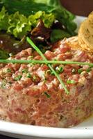 bistecca tartare con foglia insalata e rustico patate foto