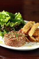 bistecca tartare con foglia insalata e rustico patate foto