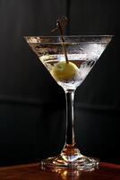 asciutto Martini, classico e famoso bevanda con Gin, asciutto vermut, Limone sbucciare e oliva foto