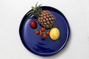 blu ceramica piatto con parecchi diverso frutta foto