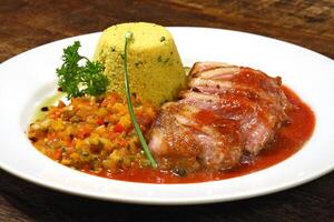 arrosto anatra con salsa e marocchino couscous su piatto foto