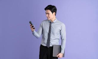 ritratto di asiatico maschio uomo d'affari in posa su viola sfondo foto