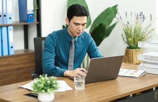 Immagine di asiatico maschio uomo d'affari Lavorando nel il ufficio foto