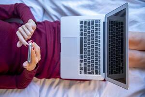 casa ufficio. il giovane donna comunica comodamente nel sua casa ufficio con il Aiuto di tecnologia e il Internet. foto