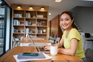 donna seduta Lavorando con il computer portatile a caffè negozio, libero professionista donna Lavorando al di fuori concetto. foto