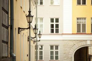 un vecchio buio strada lampada con bicchiere inserti si blocca su il parete di un' Casa nel tallin. alto qualità foto