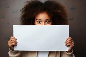 un' ragazza con afro riccioli detiene un' vuoto carta con un' modello nel sua mani. foto