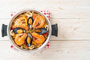 paella di mare con gamberi, vongole, cozze su riso allo zafferano foto