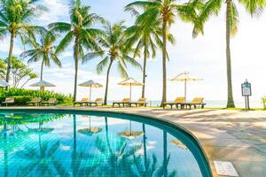 bellissimo ombrellone e sedia intorno alla piscina in hotel e resort foto