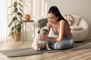 asiatico donna nel abbigliamento sportivo esercizio e fare yoga con carino cane nel vivente camera a casa, salutare stile di vita, mentale Salute concetto. foto