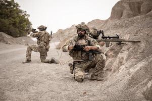 soldati nel camuffare uniformi mirando con loro fucili pronti per fuoco durante militare operazione nel il deserto soldati formazione nel un' militare operazione foto