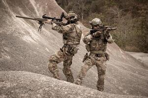 soldati nel camuffare uniformi mirando con loro fucili pronti per fuoco durante militare operazione nel il deserto soldati formazione nel un' militare operazione foto
