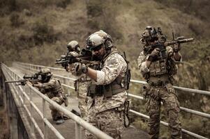 soldati nel camuffare uniformi mirando con loro fucili pronti per fuoco durante militare operazione nel il foresta soldati formazione nel un' militare operazione foto