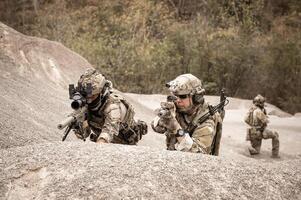 soldati nel camuffare uniformi mirando con loro fucili pronti per fuoco durante militare operazione nel il deserto soldati formazione nel un' militare operazione foto