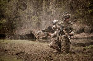 soldati nel camuffare uniformi mirando con loro fucili pronti per fuoco durante militare operazione nel il foresta soldati formazione nel un' militare operazione foto