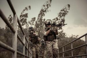 soldati nel camuffare uniformi mirando con loro fucili pronti per fuoco durante militare operazione nel il foresta soldati formazione nel un' militare operazione foto