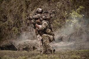 soldati nel camuffare uniformi mirando con loro fucili pronti per fuoco durante militare operazione nel il foresta soldati formazione nel un' militare operazione foto