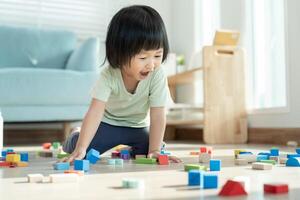 contento asiatico bambino giocando e apprendimento giocattolo blocchi. bambini siamo molto contento e eccitato a casa. bambino avere un' grande tempo giocando, attività, sviluppo, Attenzione disavanzo iperattività disturbo foto