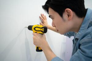 asiatico uomo misurazione e riparazione case foto